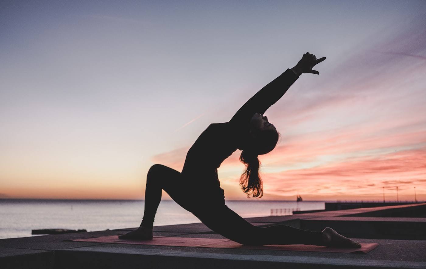 Woman practising yoga at sunset